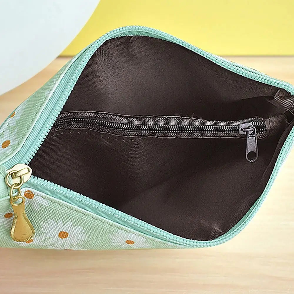 A light green coin purse made of PU leather with a zipper and a gold-colored wrist strap.