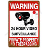 A vintage metal warning sign with red and white text indicating 24 hour video surveillance for private property no trespassin