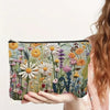 A hand holds a floral double-sided cosmetic storage pouch featuring various dried flowers and greenery.