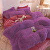 A purple plush mink velvet duvet set with pink accents and a white stuffed animal on a bed.