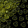 Close-up view of small, translucent yellow resin flower bead caps for jewelry making.