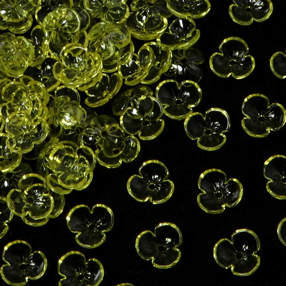 Close-up view of small, translucent yellow resin flower bead caps for jewelry making.