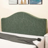 A dark olive green soft elastic headboard cover displayed on a white bed.