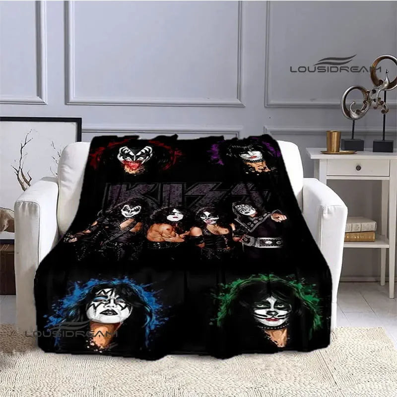 A black printed flannel travel blanket featuring dark, stylized faces and skulls.