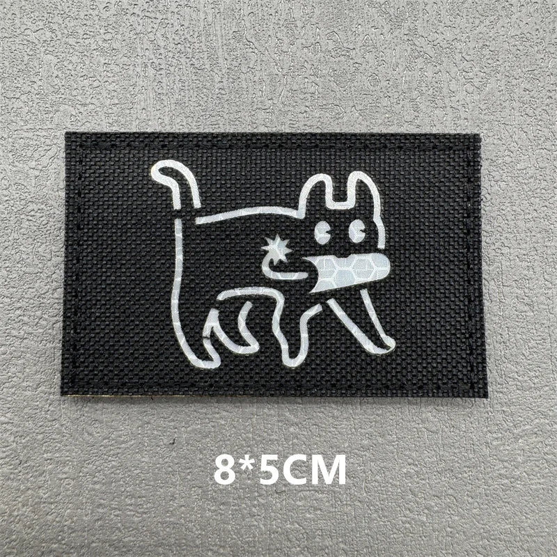Black embroidered patch featuring a white outline of a cat with a paw print.