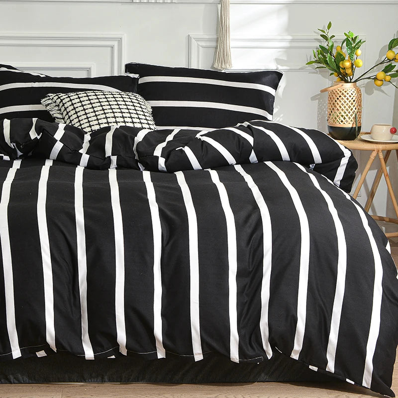 Black and white striped duvet cover set with pillows on a bed against a white wall.