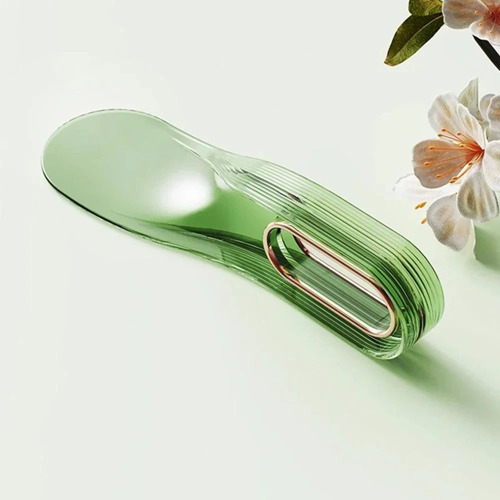 A translucent green mattress lifter wedge is shown on a light surface.