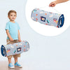 A toddler is holding a rolled-up gray and white nap mat with colorful decorations.