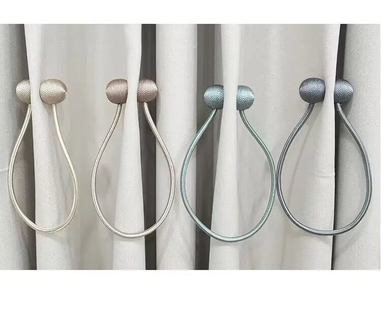 A set of two pearl-colored rope tieback hair accessories with decorative grips shown against a white curtain.