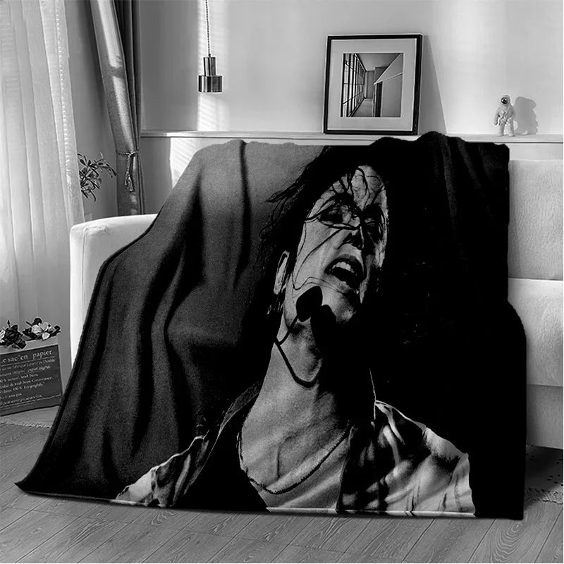 A black and white photograph of a person's face partially obscured by a dark fabric, resting on a wooden floor.