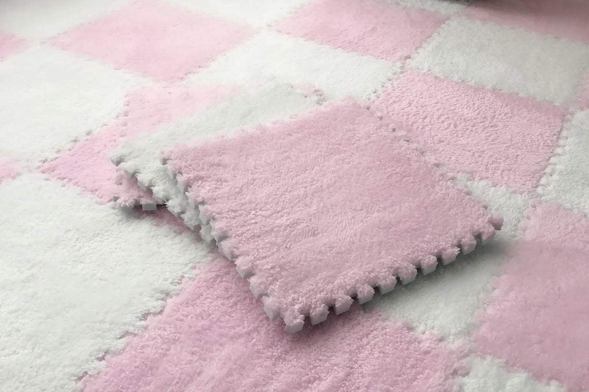 A pink and white checkered rug mat with a square pink plush mat placed on it.