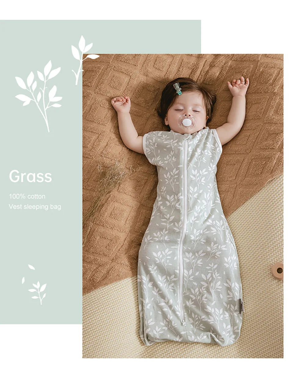 A baby is sleeping in a light gray cotton vest sleeping bag on a woven brown blanket.