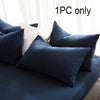 A set of dark blue and cream pillows on a bed, showing one pillowcase with an envelope closure.