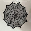 A black disposable table runner placemat featuring an intricate spider web design.