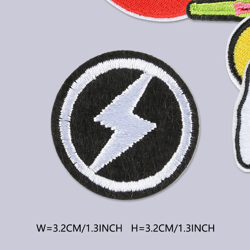A round black patch with a white lightning bolt design and white stitching on a gray background.