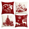 A set of four festive red and white Christmas themed decorative pillows featuring reindeer, snowflakes, and a pine tree.