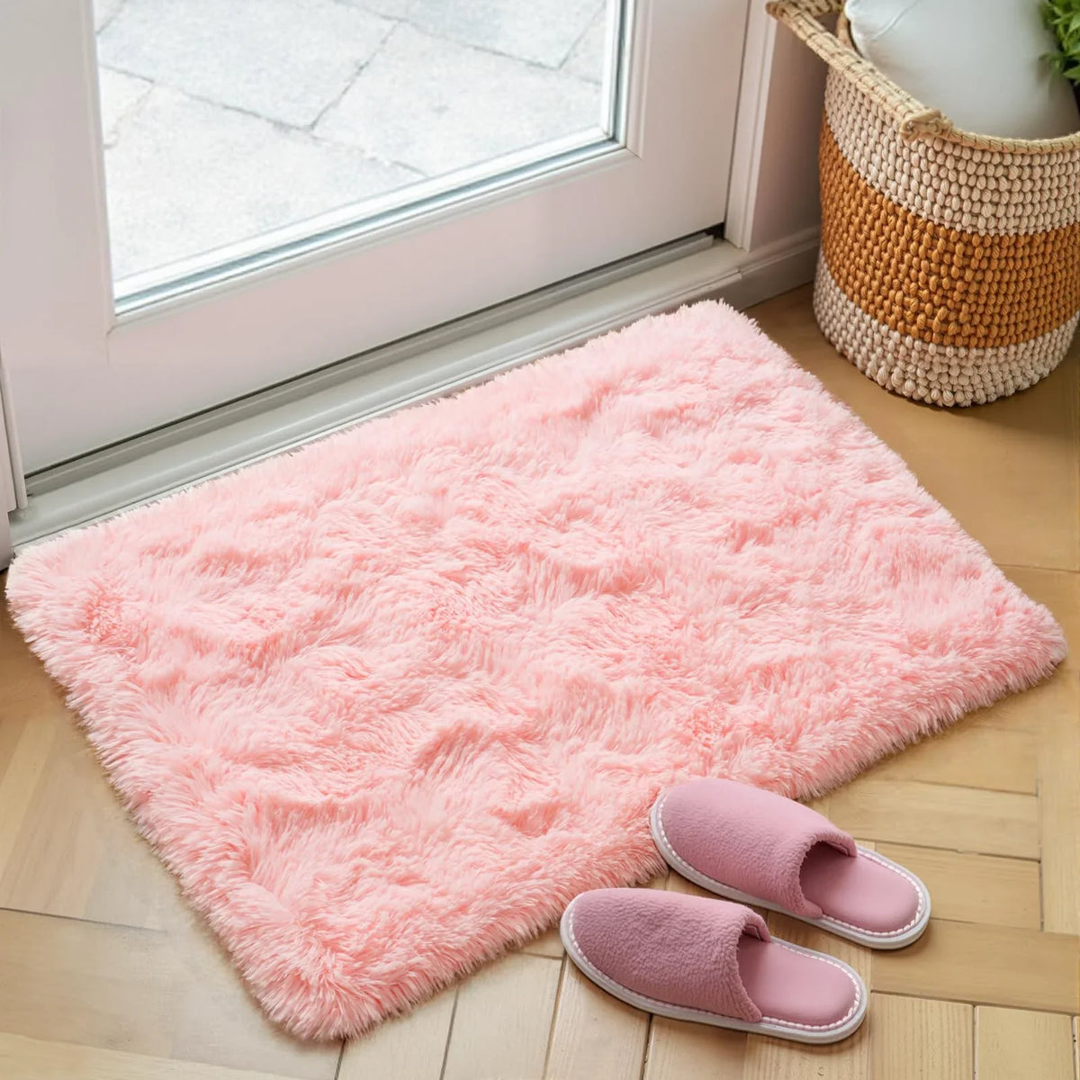 A fluffy pink bedroom carpet with a non-slip backing is displayed on a wooden floor.