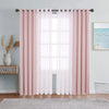 A set of pink sheer and blackout window drapes hanging on a rod in a bright room.