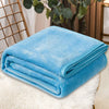 A folded bright blue coral fleece throw blanket resting on a white fluffy surface.