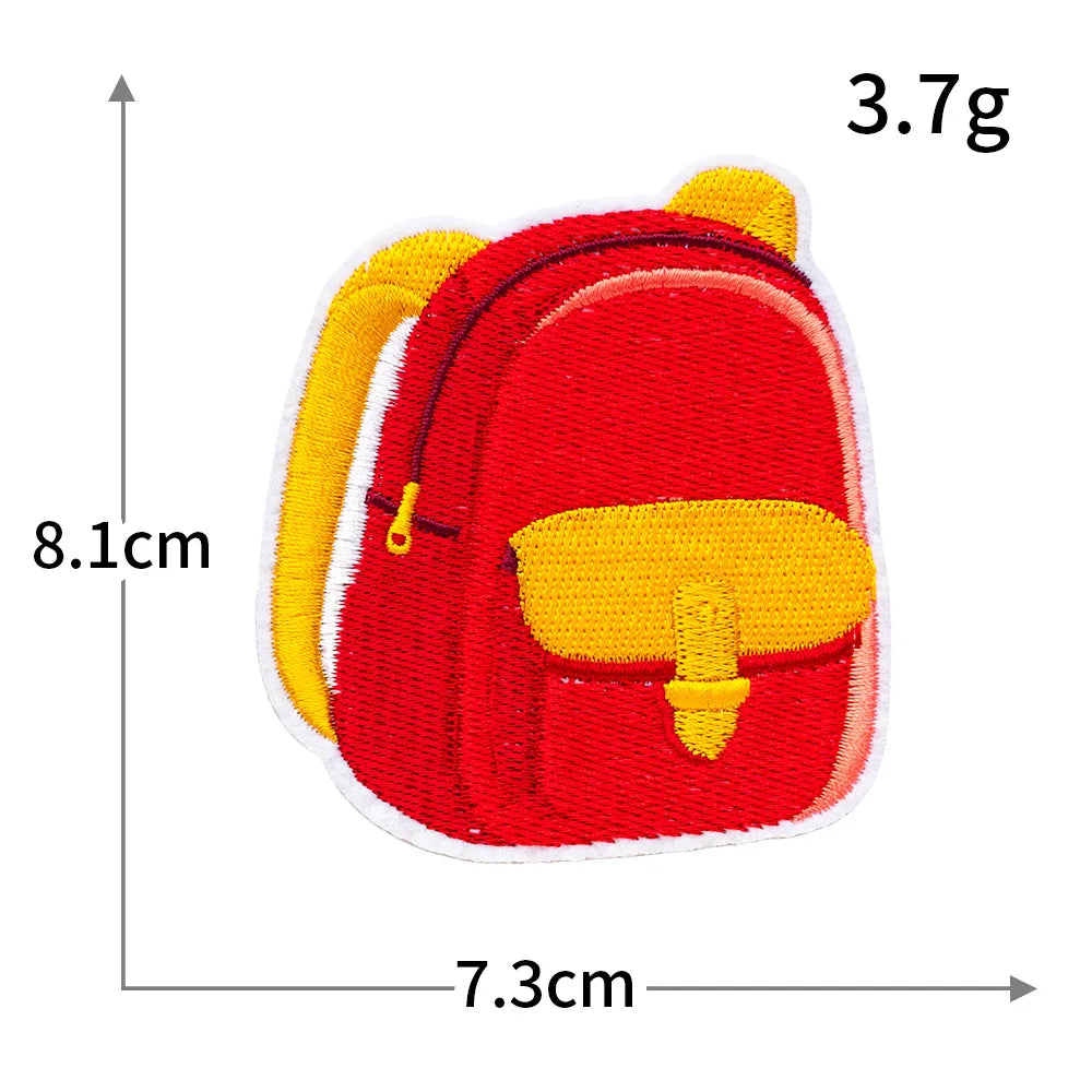 A red iron-on patch shaped like a small backpack with yellow accents.