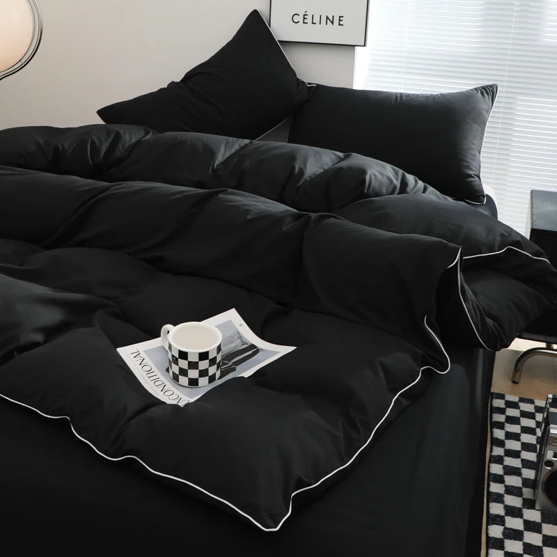 A black duvet cover set with a white and black checkered mug resting on the fabric.