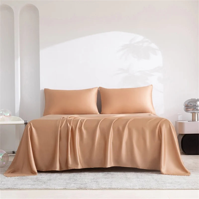 A tan luxury organic bamboo bed sheet set draped on a bed in a bright, minimalist room.