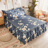 A navy blue double layer printed bed skirt with a white floral pattern on a bed.