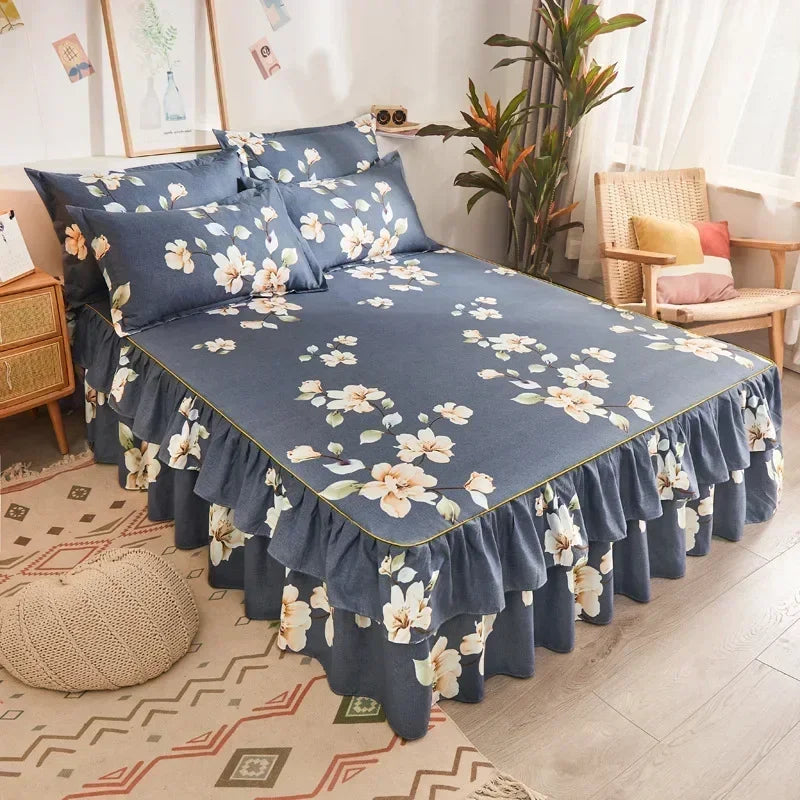 A navy blue double layer printed bed skirt with a white floral pattern on a bed.