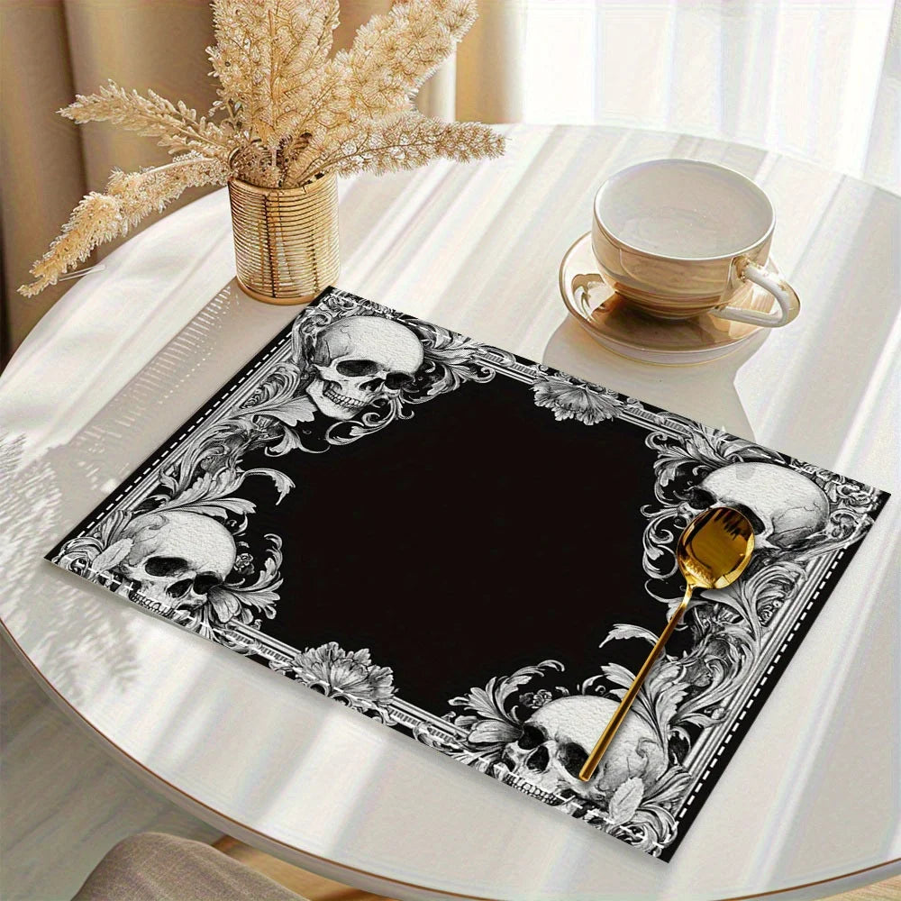 A black placemat featuring a vintage gothic floral design with skulls and mystic cross elements on a white table.