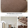 A close-up of a brown patterned jacquard sofa cover featuring a textured, geometric design.