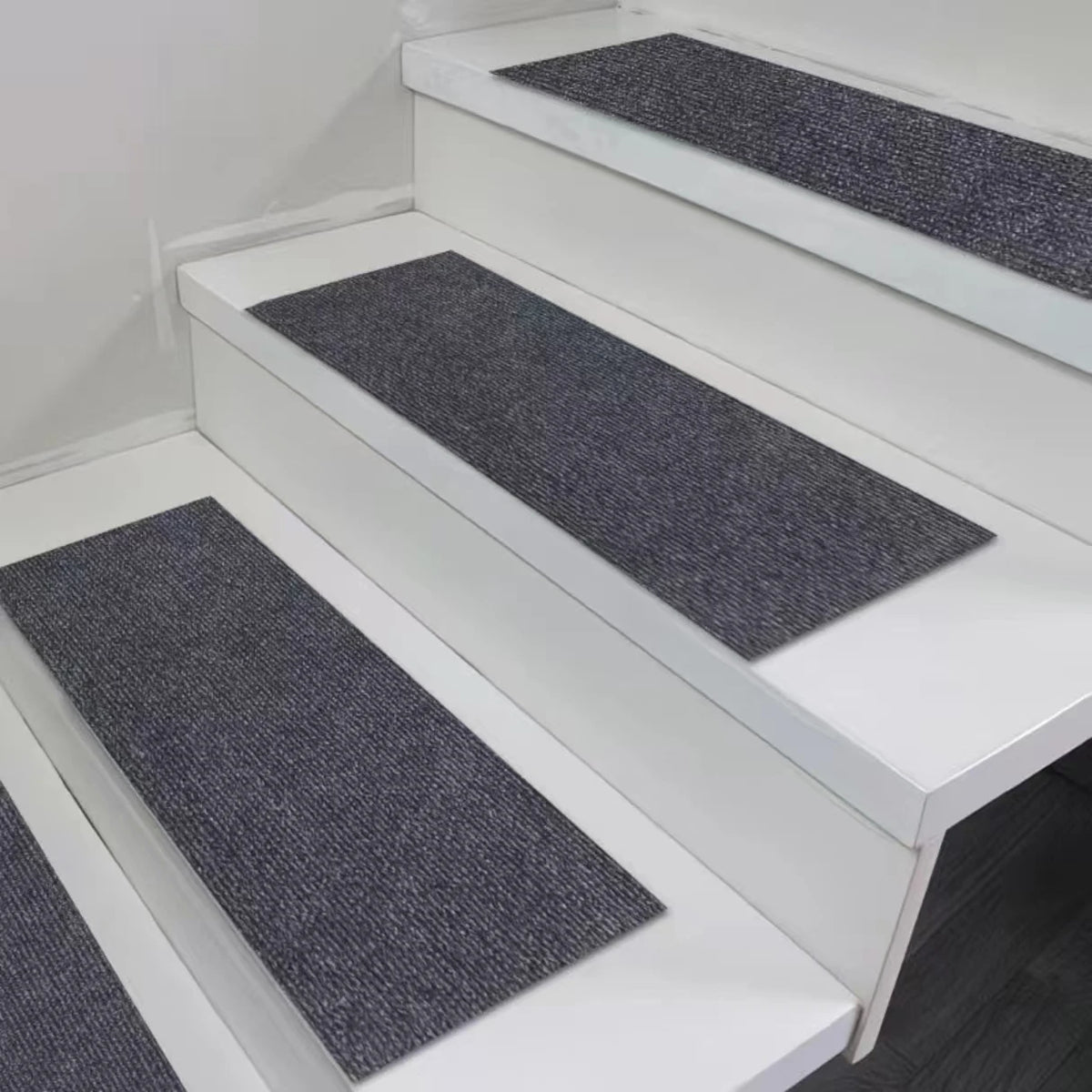 White staircase with dark gray self-adhesive mats on the steps