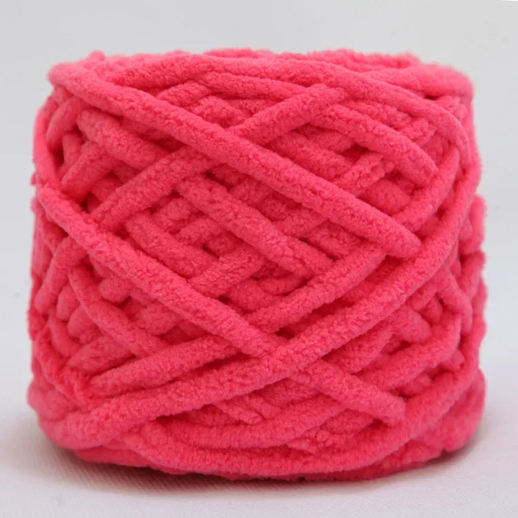 A ball of bright pink chenille knitting yarn used for hand crafting.