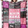 A colorful knit blanket featuring pink and black patterns with Spanish words like Gracias and Amor
