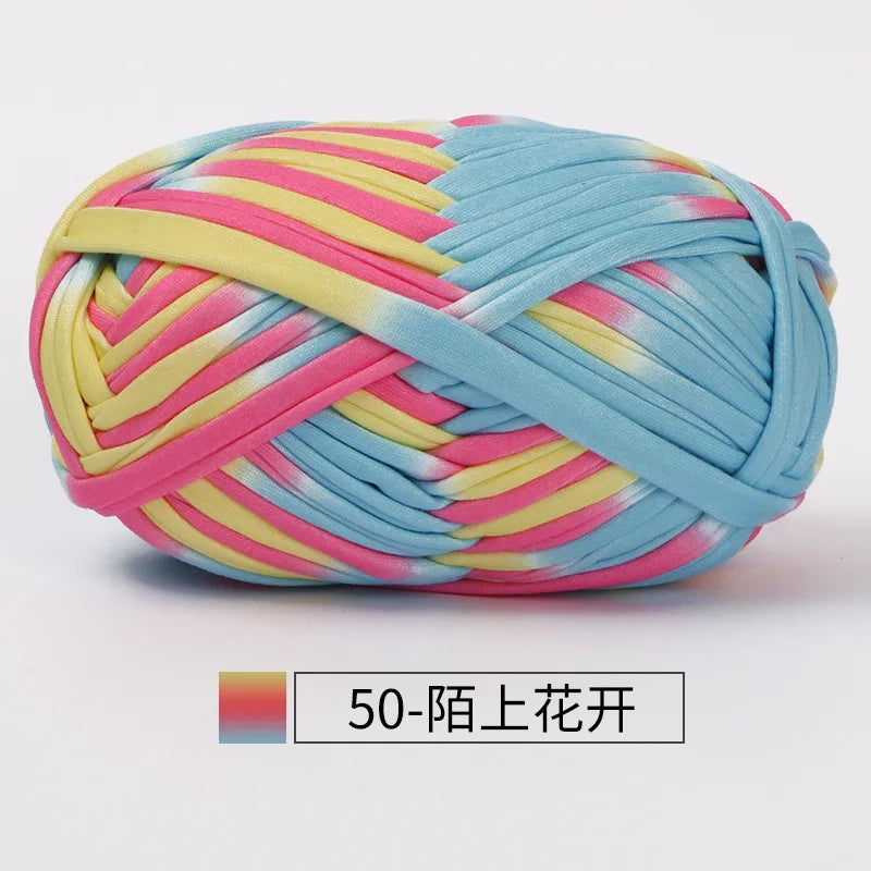 A ball of hand-dyed fabric strip yarn featuring pink, yellow, and light blue stripes.