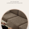 A close-up view of a brown jacquard textured sofa cushion cover being touched by a hand.