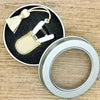 Mini precision sewing scissors with a protective cover and a gold-colored tassel on a black background