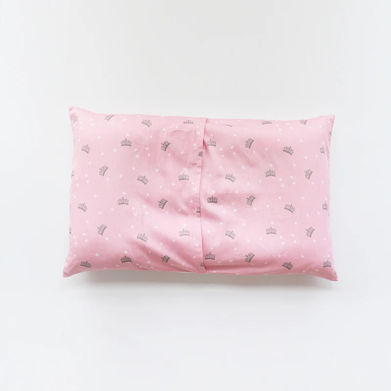 A pink soft cotton baby pillow cover with a repeating pattern of small crowns.