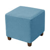 A square blue jacquard stretch ottoman slipcover with a diamond pattern.
