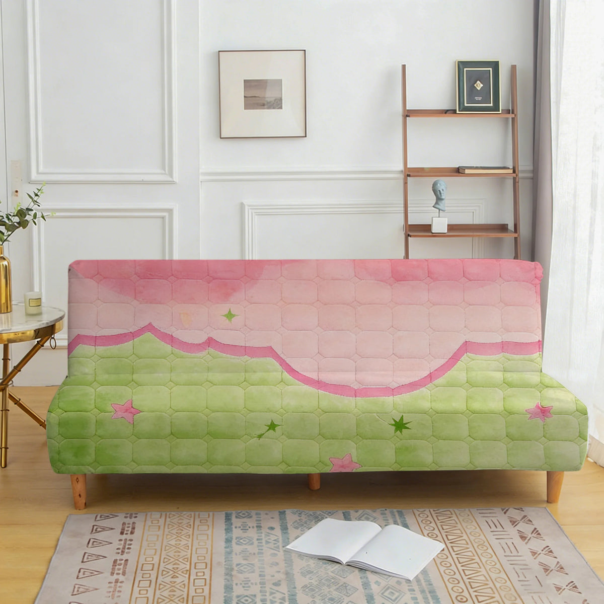 A light pink and green quilted sofa cover displayed on a wooden frame with a white wall background.