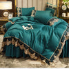 A teal bed skirt set featuring elegant gold lace trim and luxurious fabric on a bed.