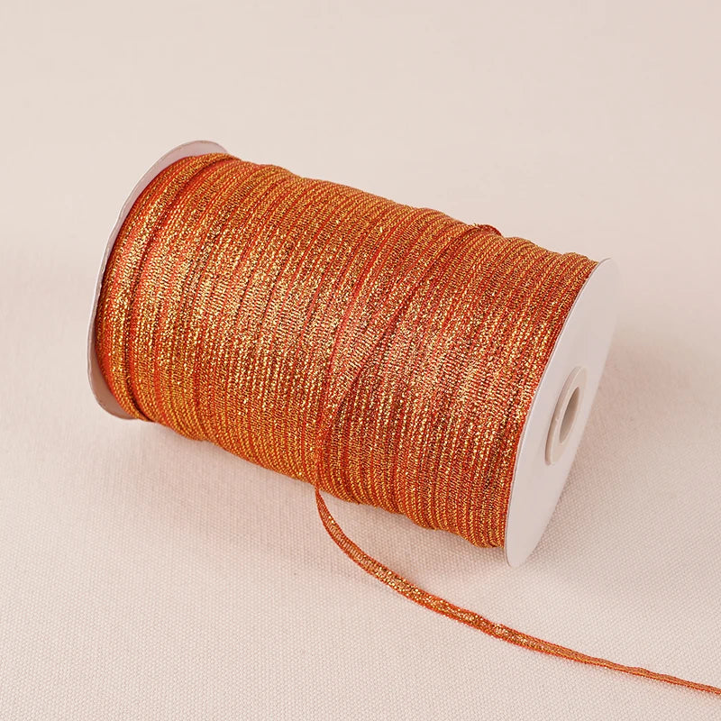 A roll of 10-meter gold and silver glitter satin ribbon with a white core.