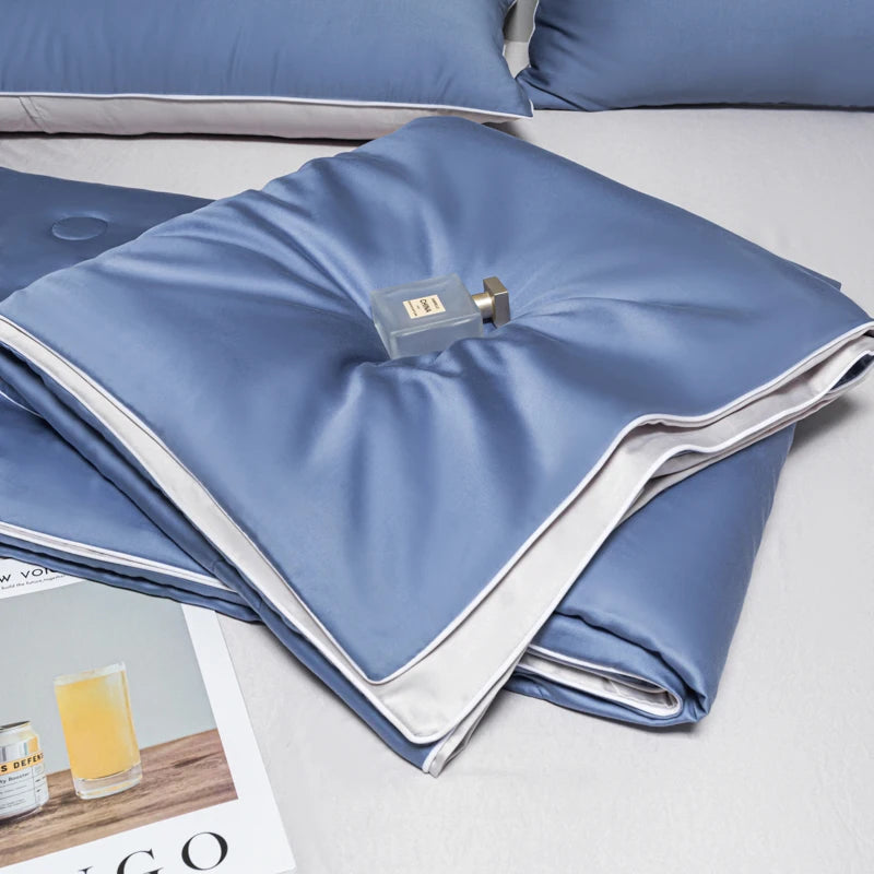 Light blue ice silk cooling quilt folded on a white surface.