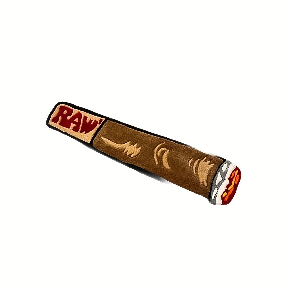 A decorative cigarette shaped floor mat with a brown felt body and an orange and white tip.