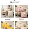 A collection of decorative plush pillow covers in various shades including beige, yellow, and white, displayed on a sofa.