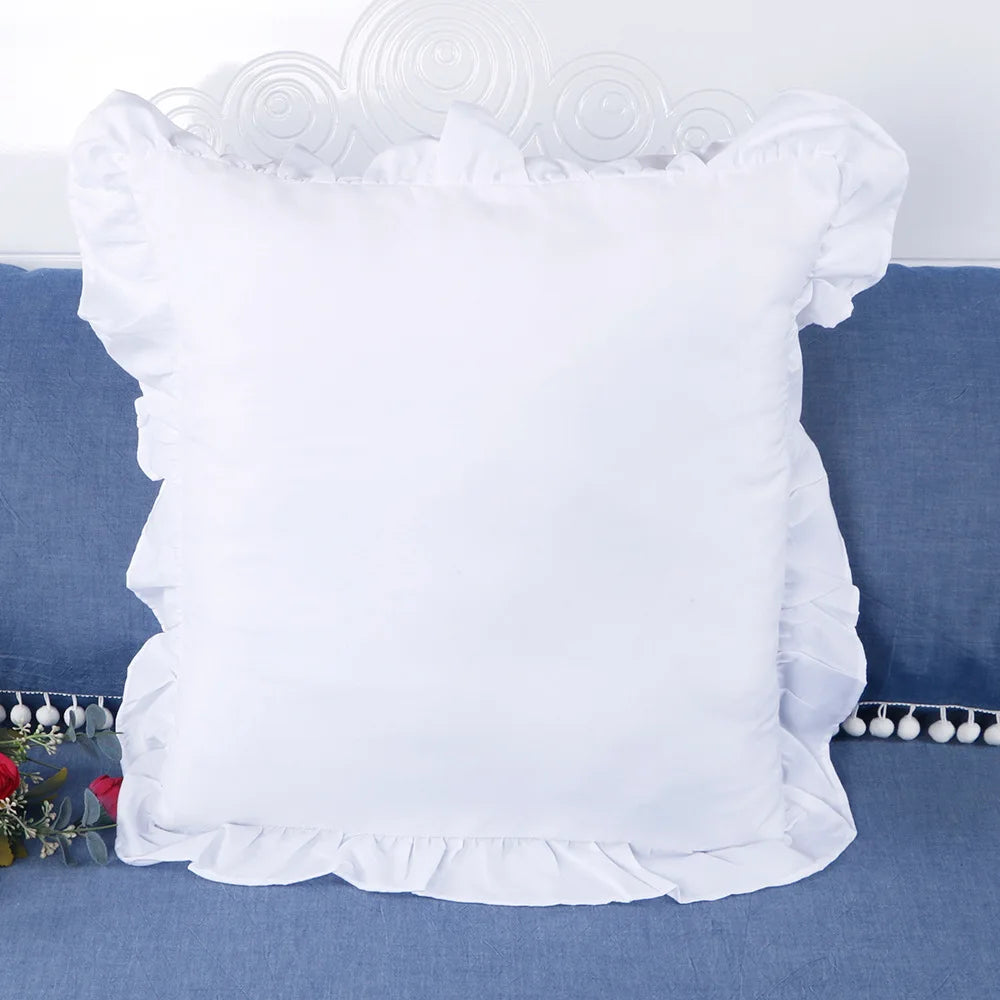 White farmhouse ruffled pillow covers displayed on a blue fabric surface.