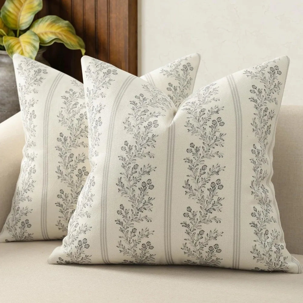 A close-up of a vintage striped floral throw pillow cover with gray botanical patterns on a light background.