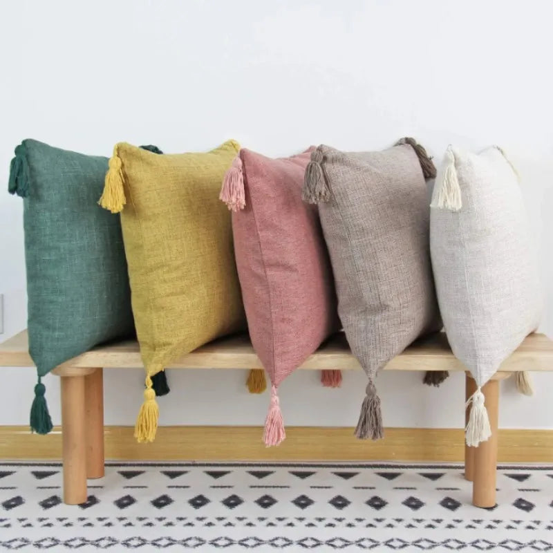 A row of boho cotton linen throw pillow covers in shades of sage green, mustard yellow, dusty rose, and gray.