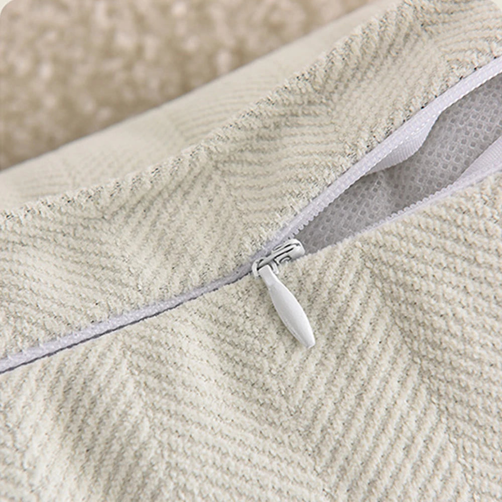 Close-up of a light beige chenille throw pillow cover with a visible zipper detail.