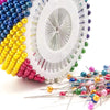 A set of pearl head pins with various colors and finishes for sewing and crafting.