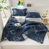 A navy blue lightweight cooling summer quilt set featuring embroidered fish designs and matching pillows on a white bed.